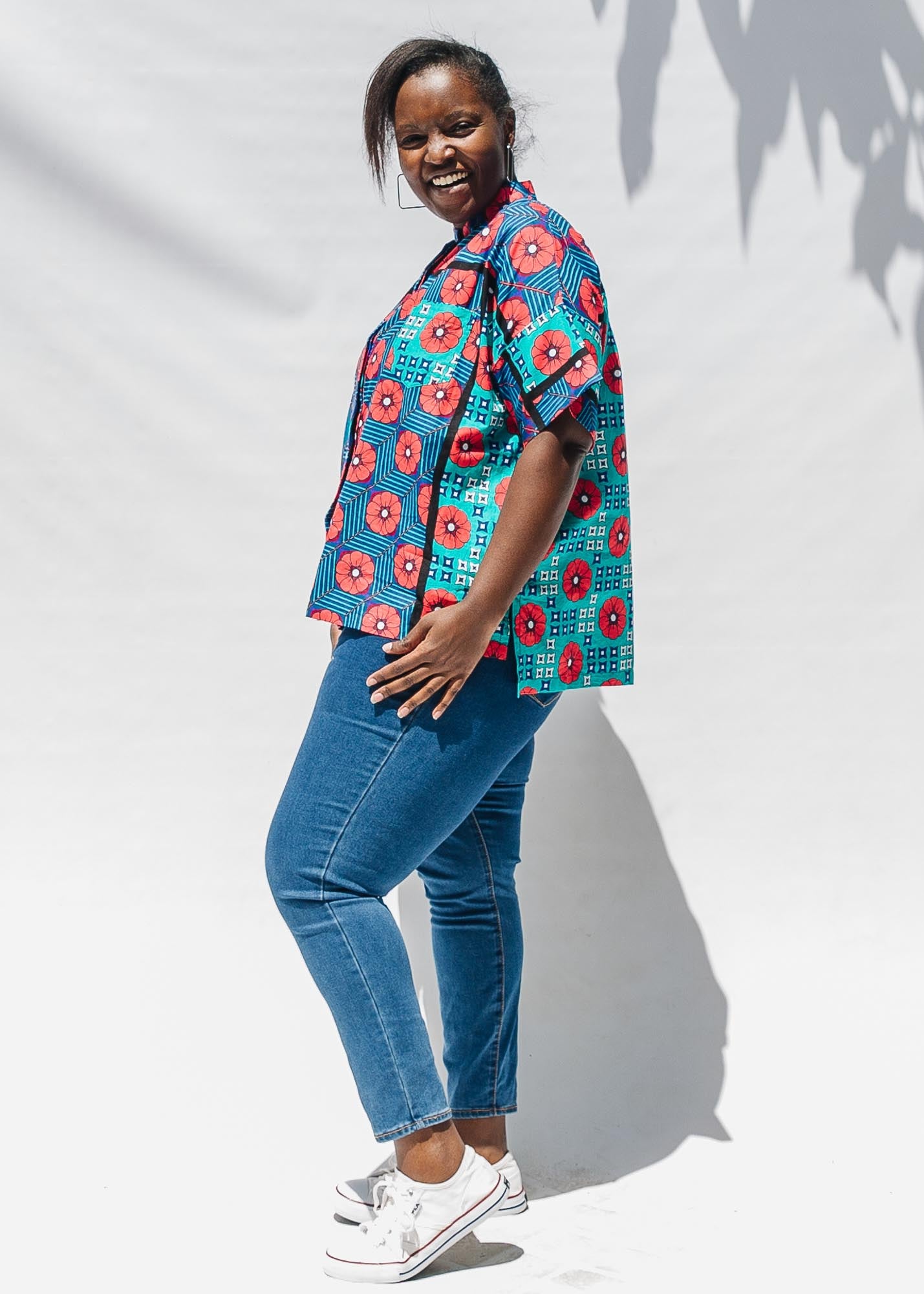 The model is wearing blue, pink, turquoise, black and white mixed pattern floral print shirt