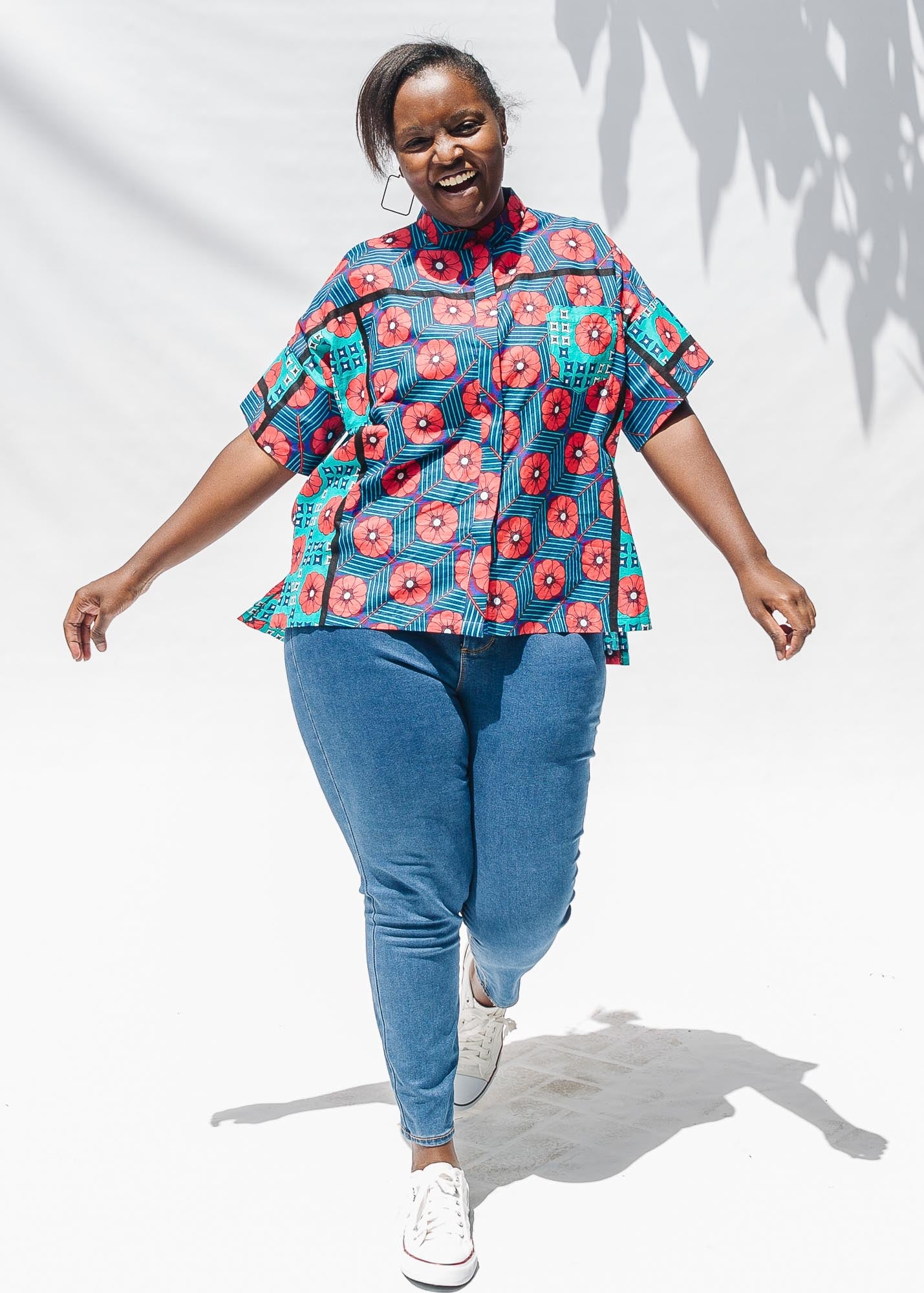 The model is wearing blue, pink, turquoise, black and white mixed pattern floral print shirt