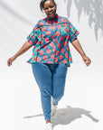 The model is wearing blue, pink, turquoise, black and white mixed pattern floral print shirt