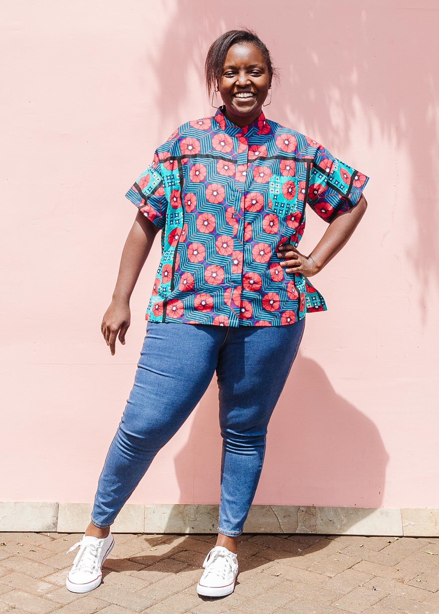 The model is wearing blue, pink, turquoise, black and white mixed pattern floral print shirt