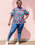 The model is wearing blue, pink, turquoise, black and white mixed pattern floral print shirt