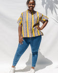 The model is wearing olive-yellow, blue, orange and white geometric printed shirt