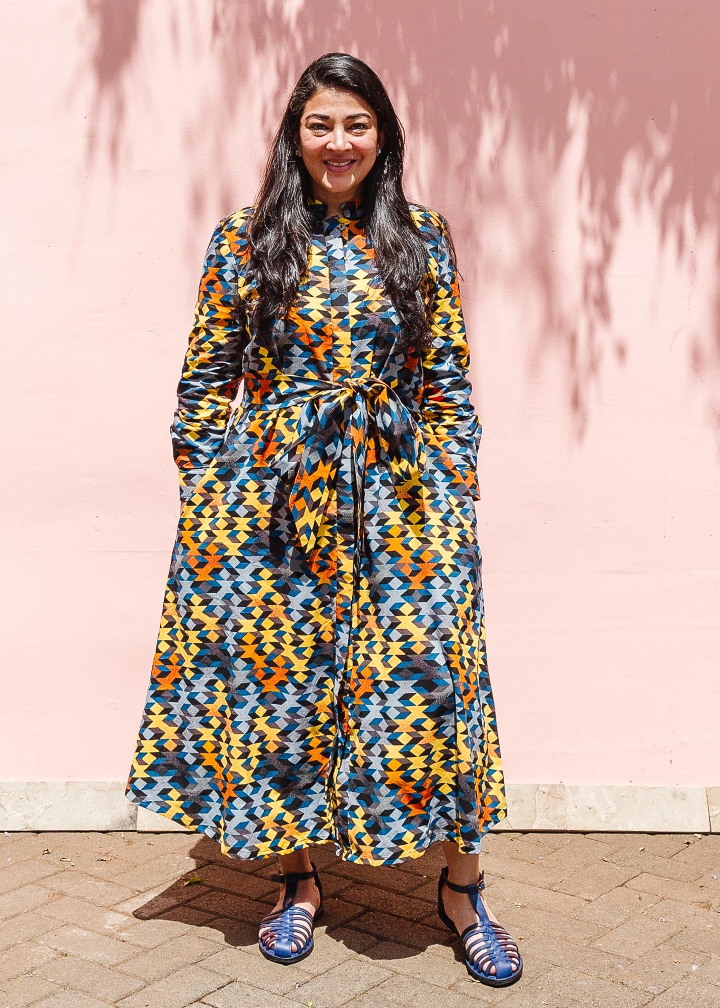 The model is wearing colorful geometric print dress