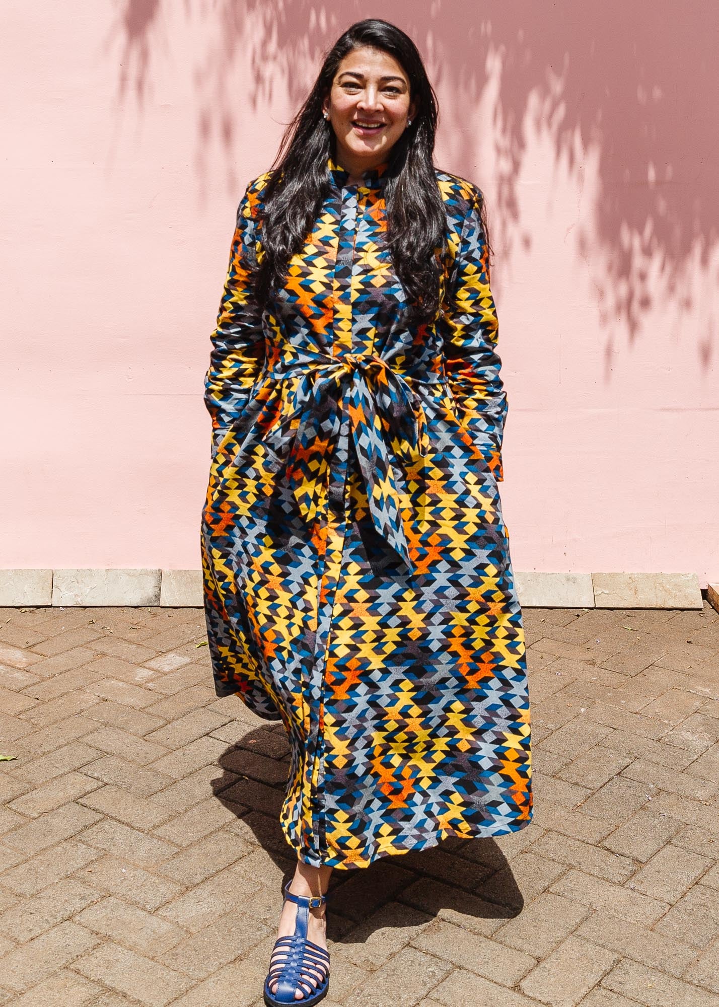 The model is wearing colorful geometric print dress