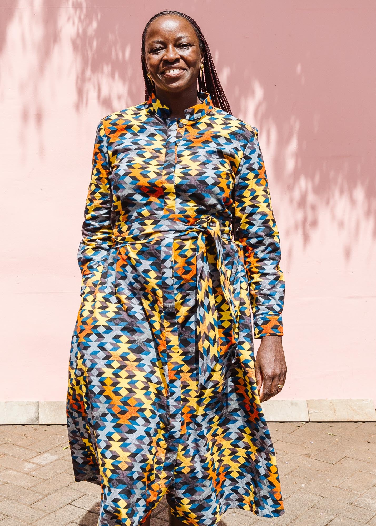 The model is wearing colorful geometric print dress