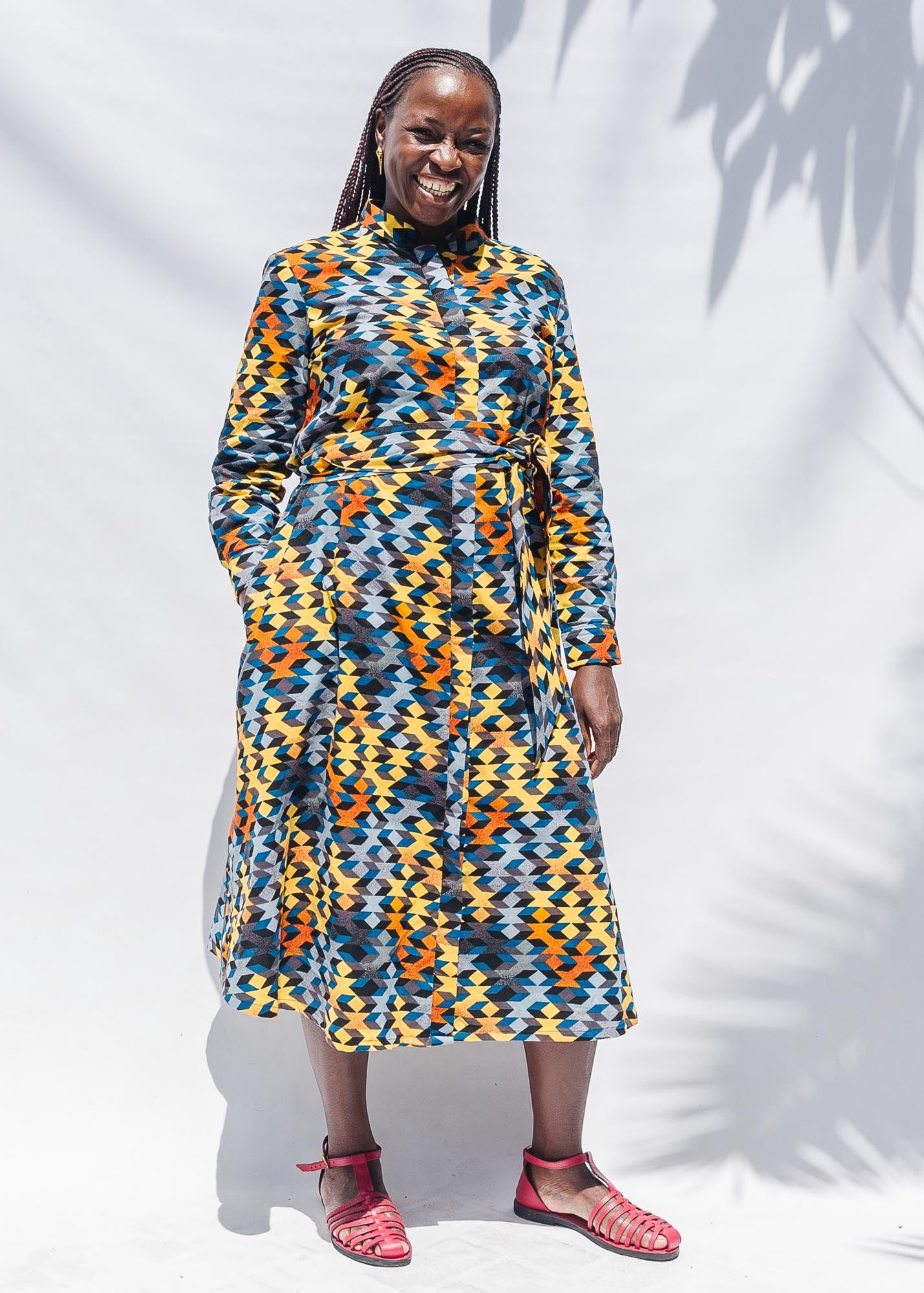 The model is wearing colorful geometric print dress