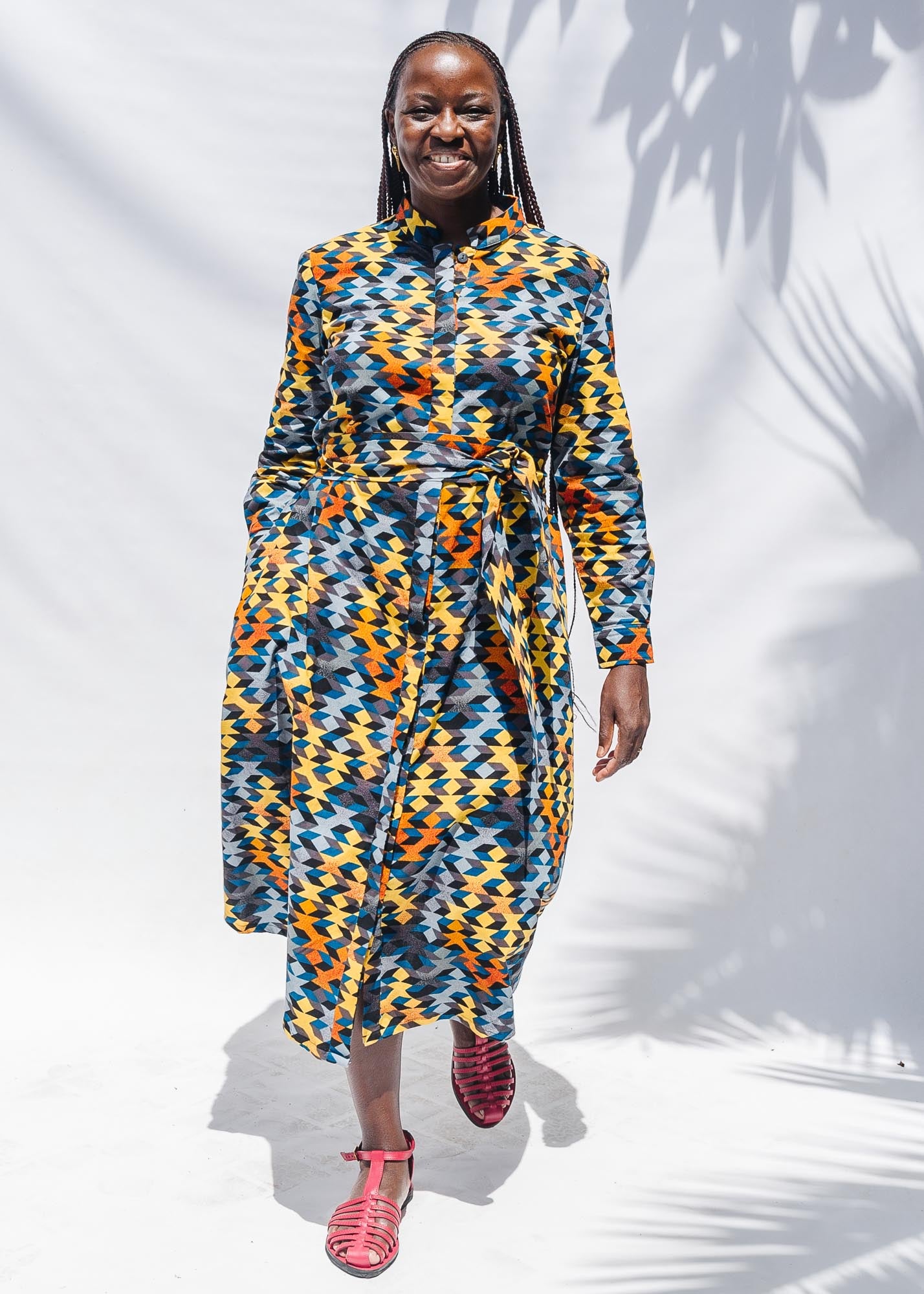 The model is wearing colorful geometric print dress