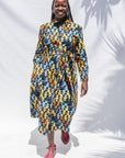 The model is wearing colorful geometric print dress