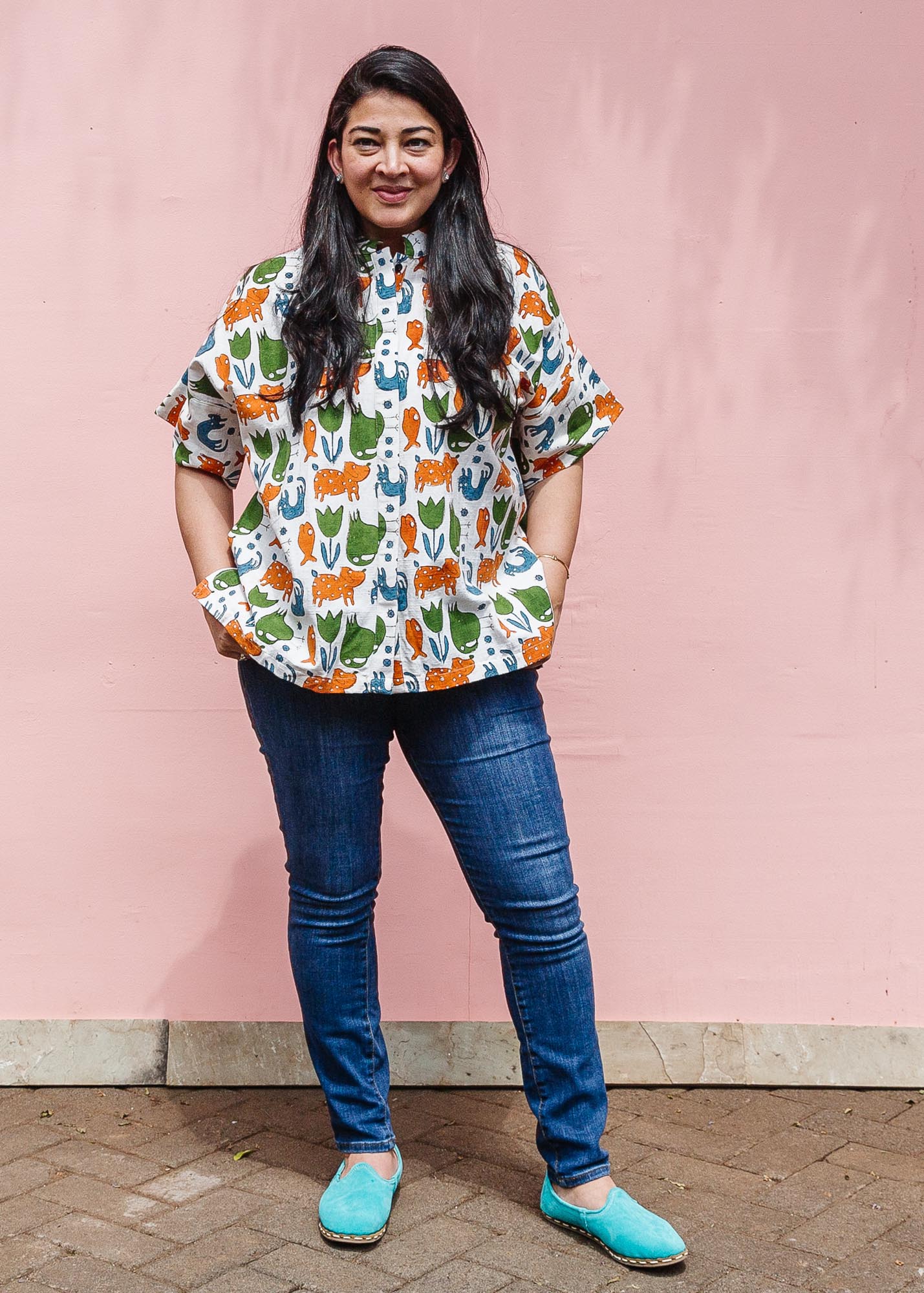 The model is wearing blue, orange, green, brown, white and black print shirt