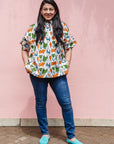 The model is wearing blue, orange, green, brown, white and black print shirt