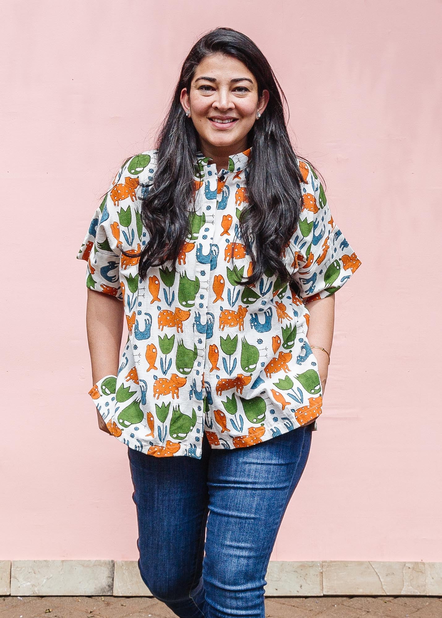 The model is wearing blue, orange, green, brown, white and black print shirt