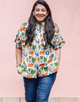 The model is wearing blue, orange, green, brown, white and black print shirt