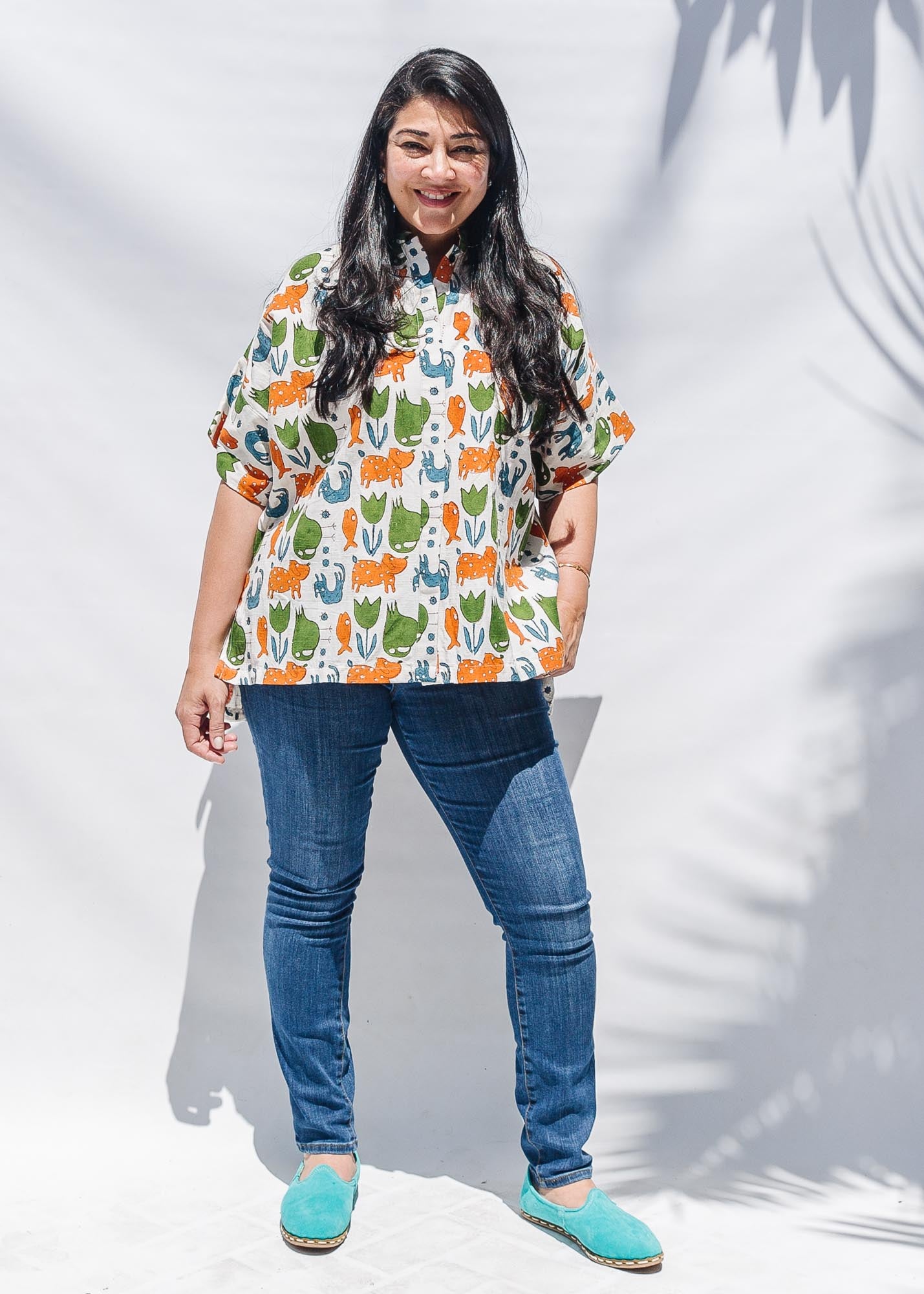 The model is wearing blue, orange, green, brown, white and black print shirt