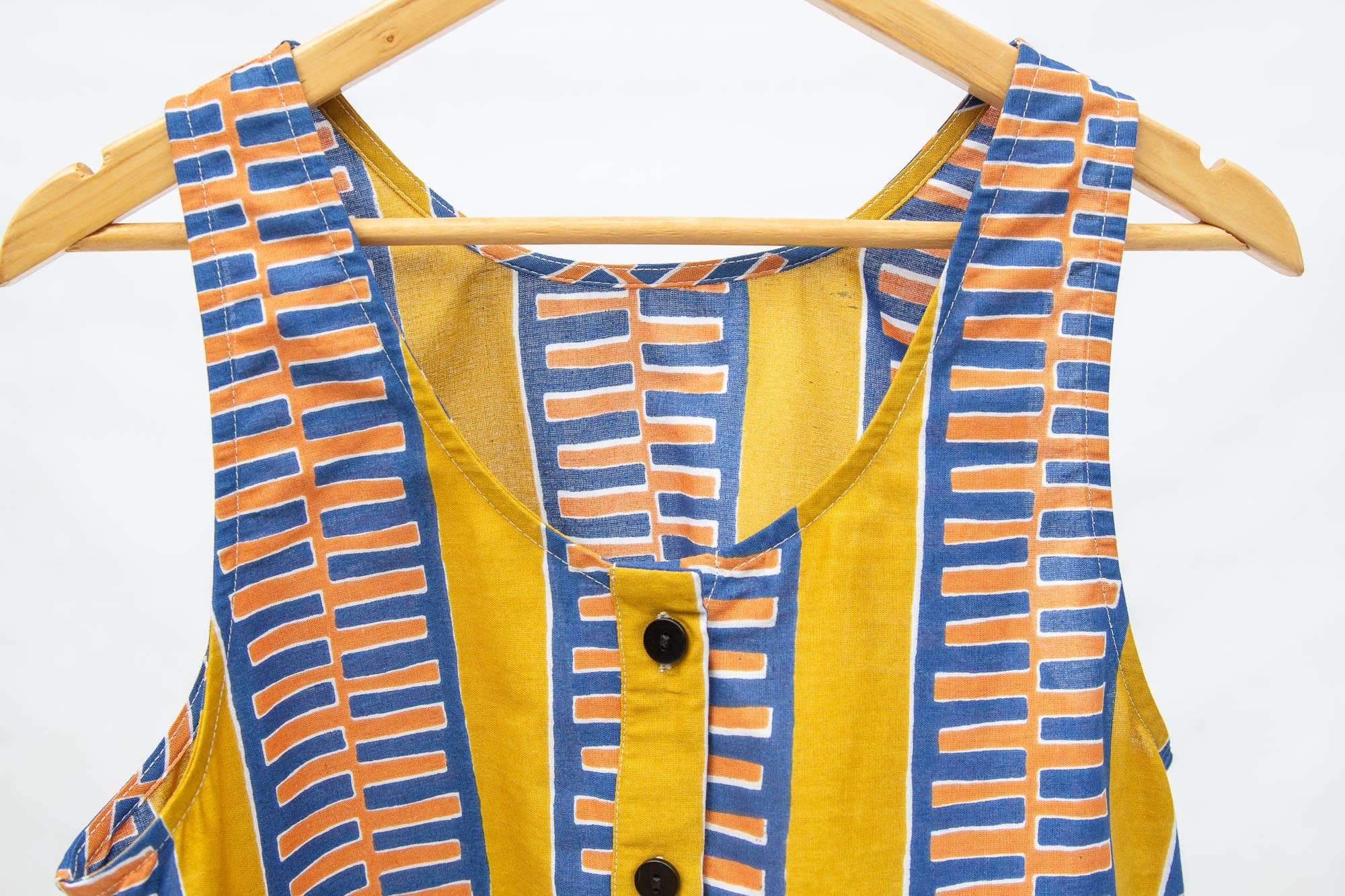 Close up display olive-yellow, blue, orange and white geometric printed tank