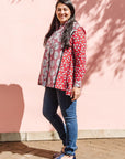 The model is wearing red, black, white print shirt