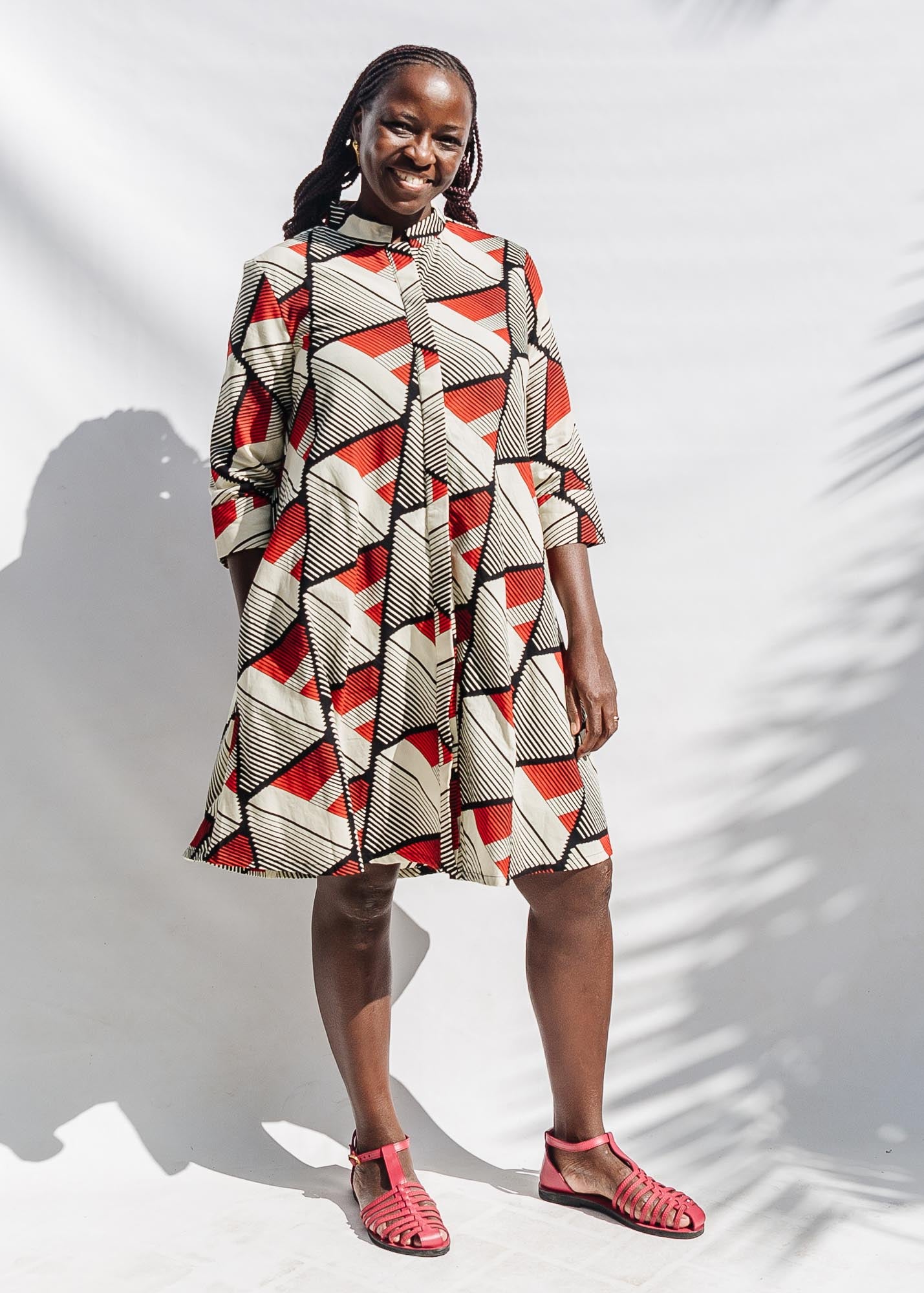 The model is wearing black, red, off white print dress