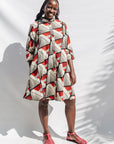 The model is wearing black, red, off white print dress