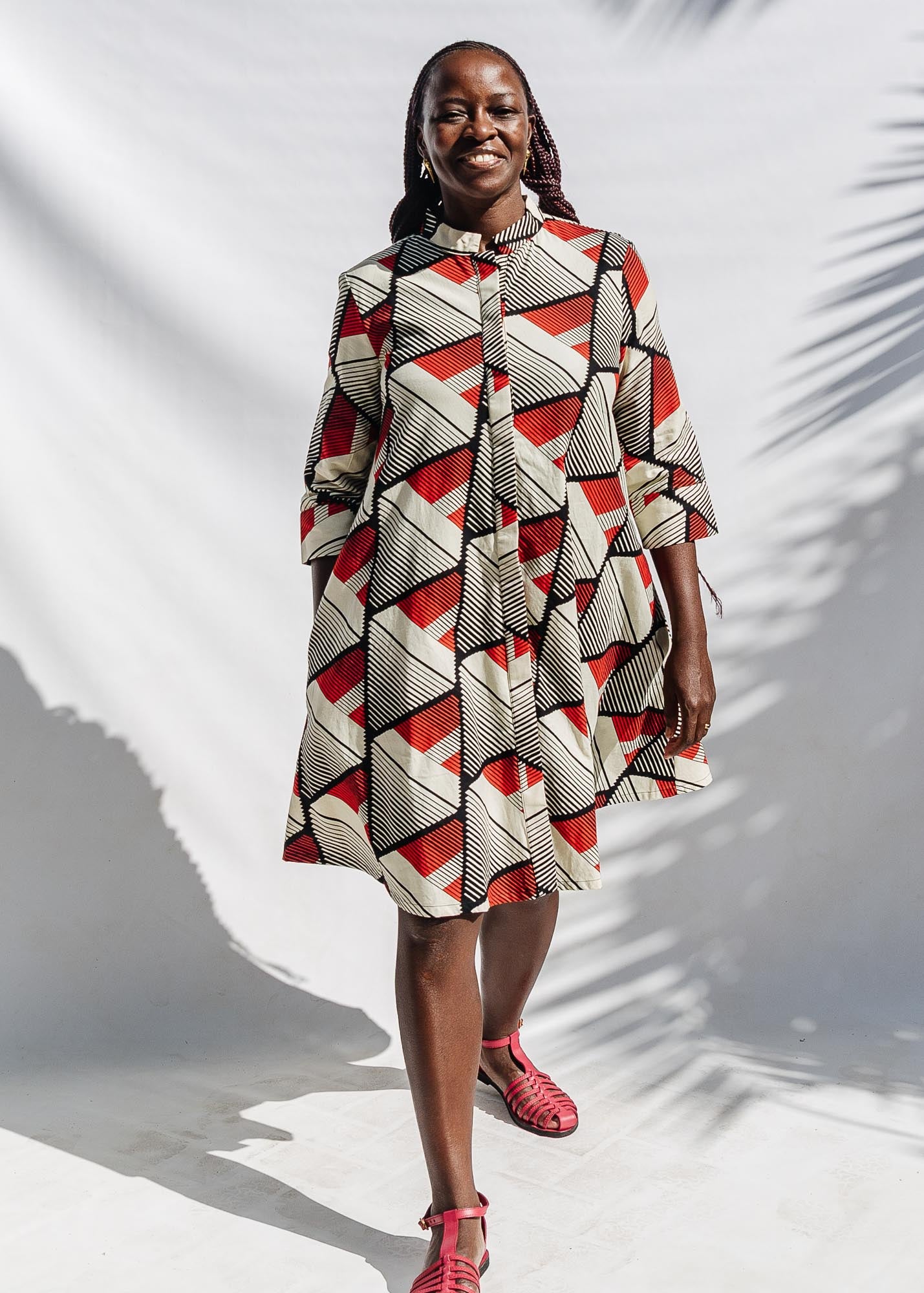 The model is wearing black, red, off white print dress