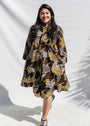 The model is wearing black, brown, yellow, beige print dress 