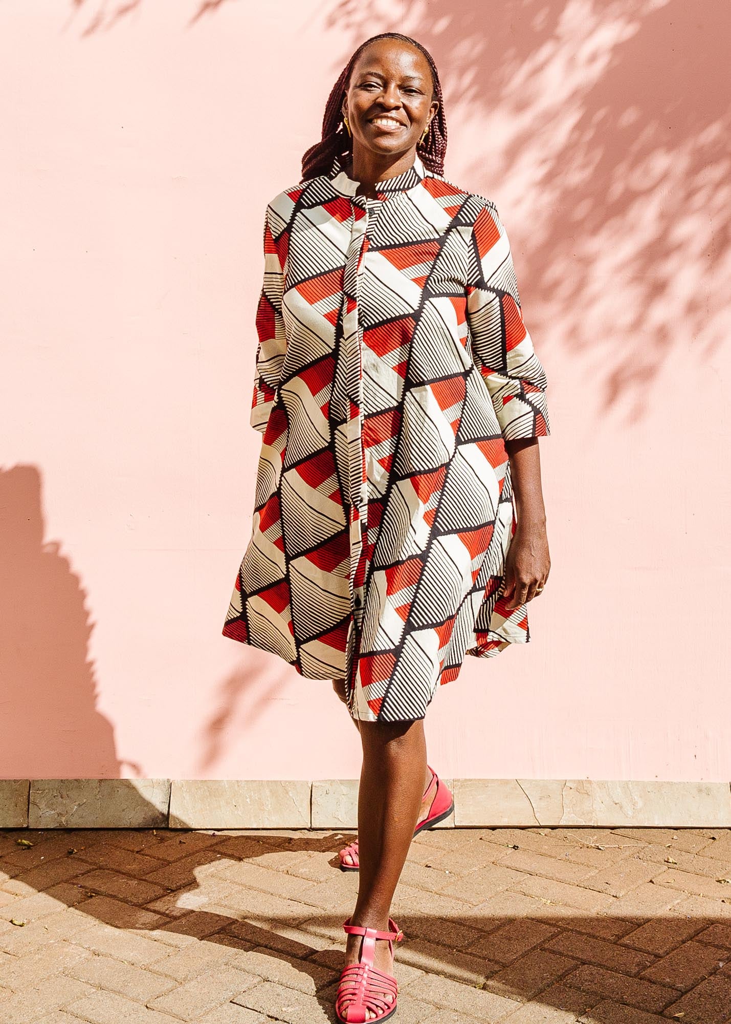 The model is wearing black, red, off white print dress