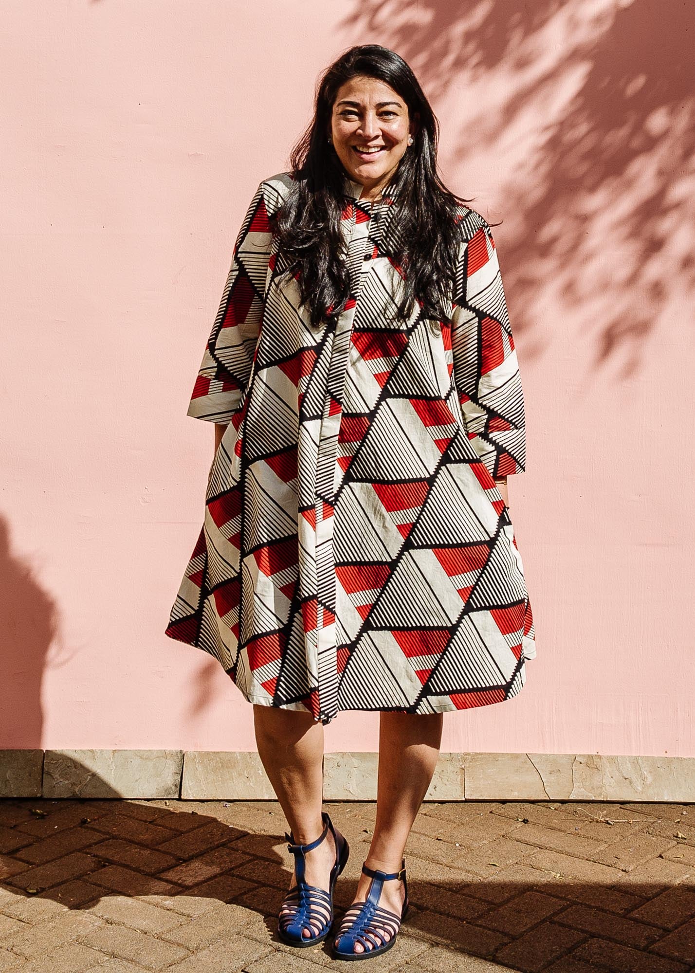 The model is wearing black, red, off white print dress