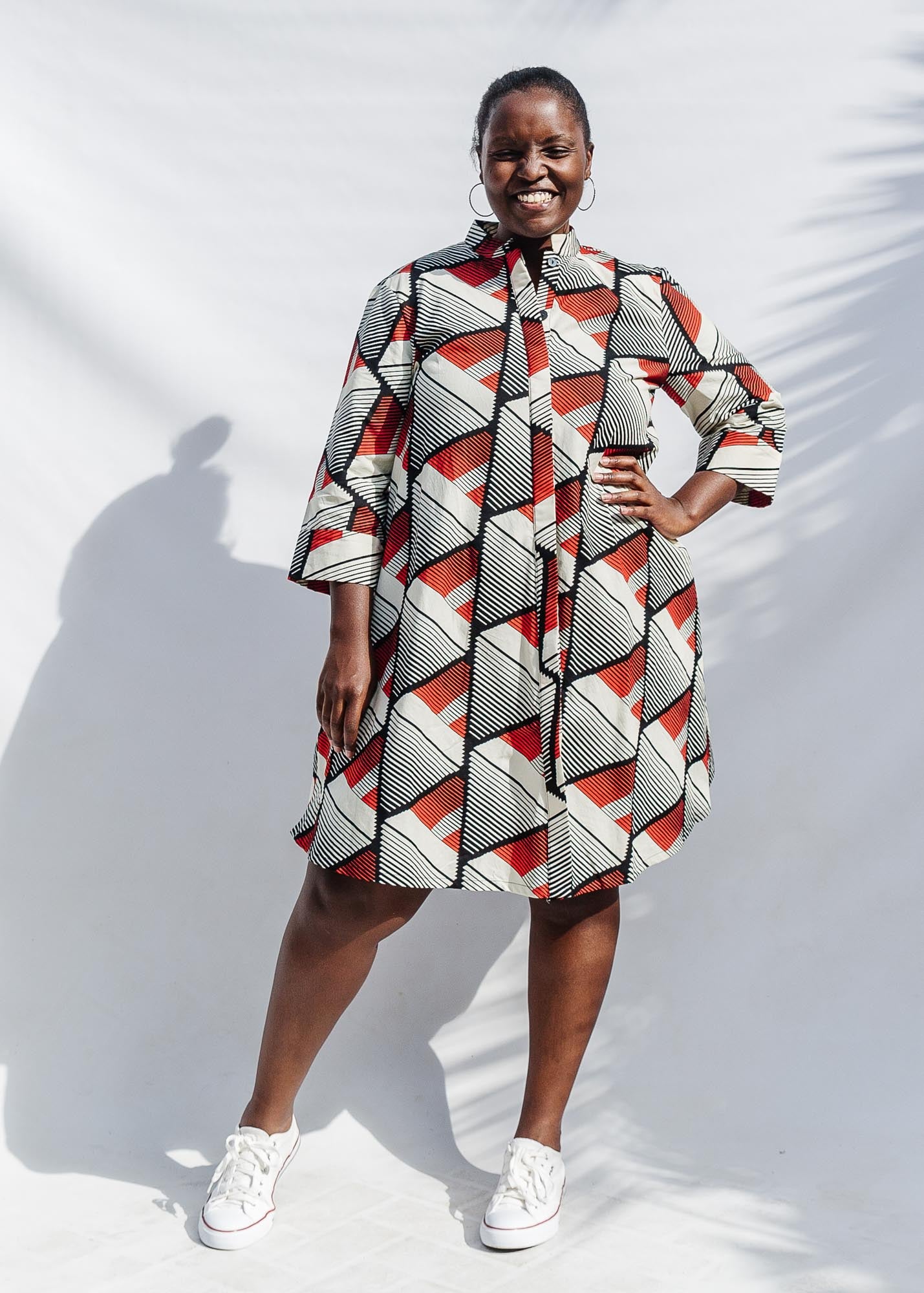 The model is wearing black, red, off white print dress