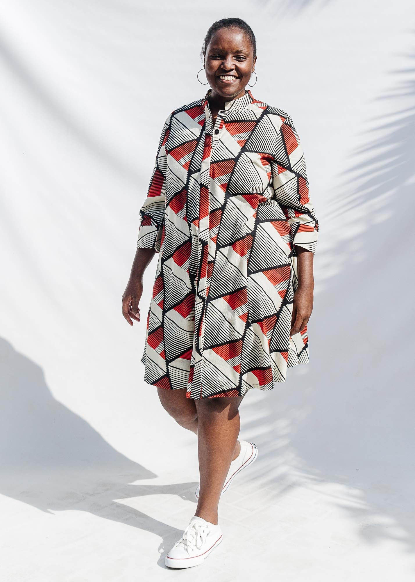 The model is wearing black, red, off white print dress