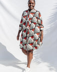 The model is wearing black, red, off white print dress