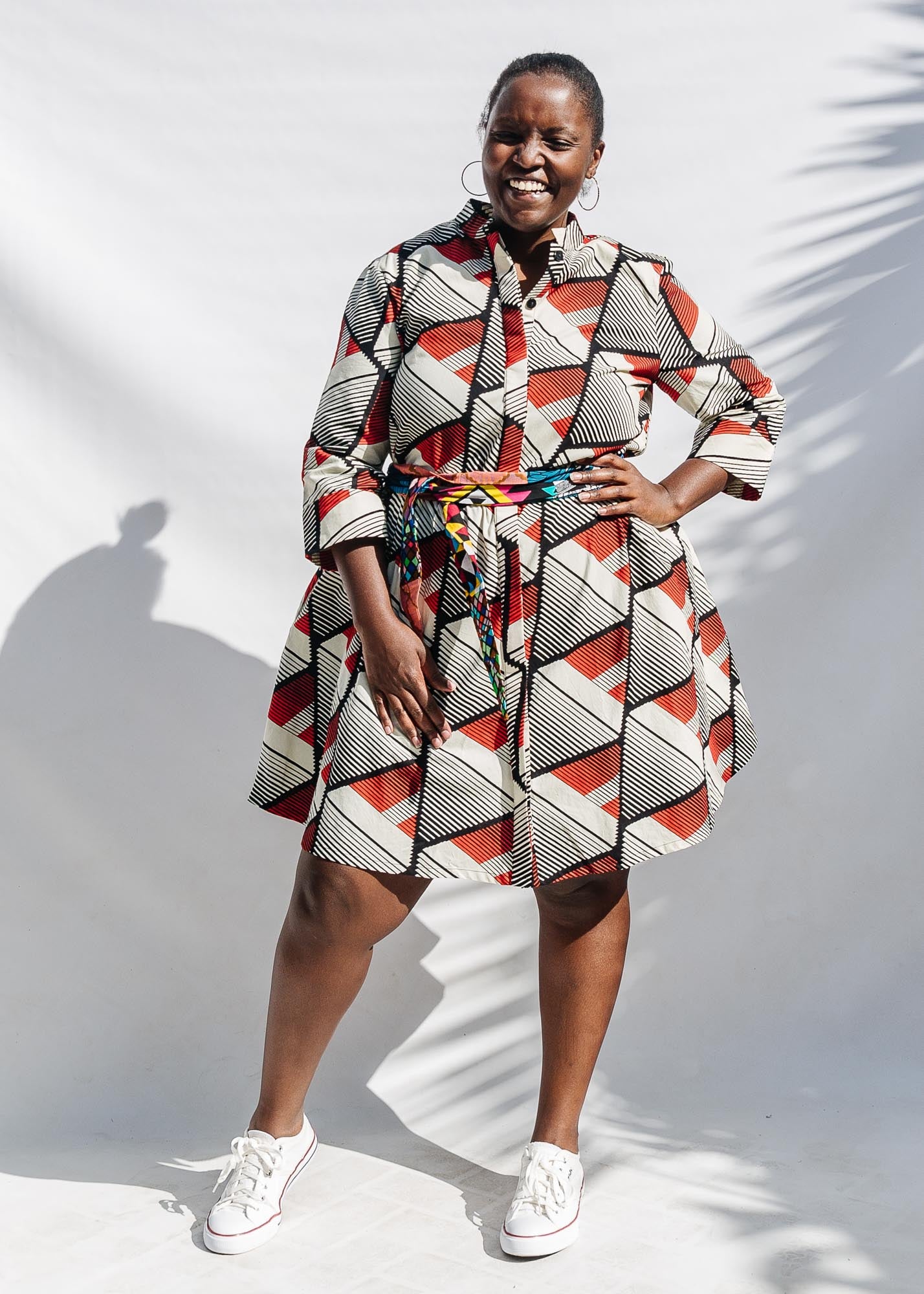 The model is wearing black, red, off white print dress