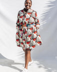 The model is wearing black, red, off white print dress