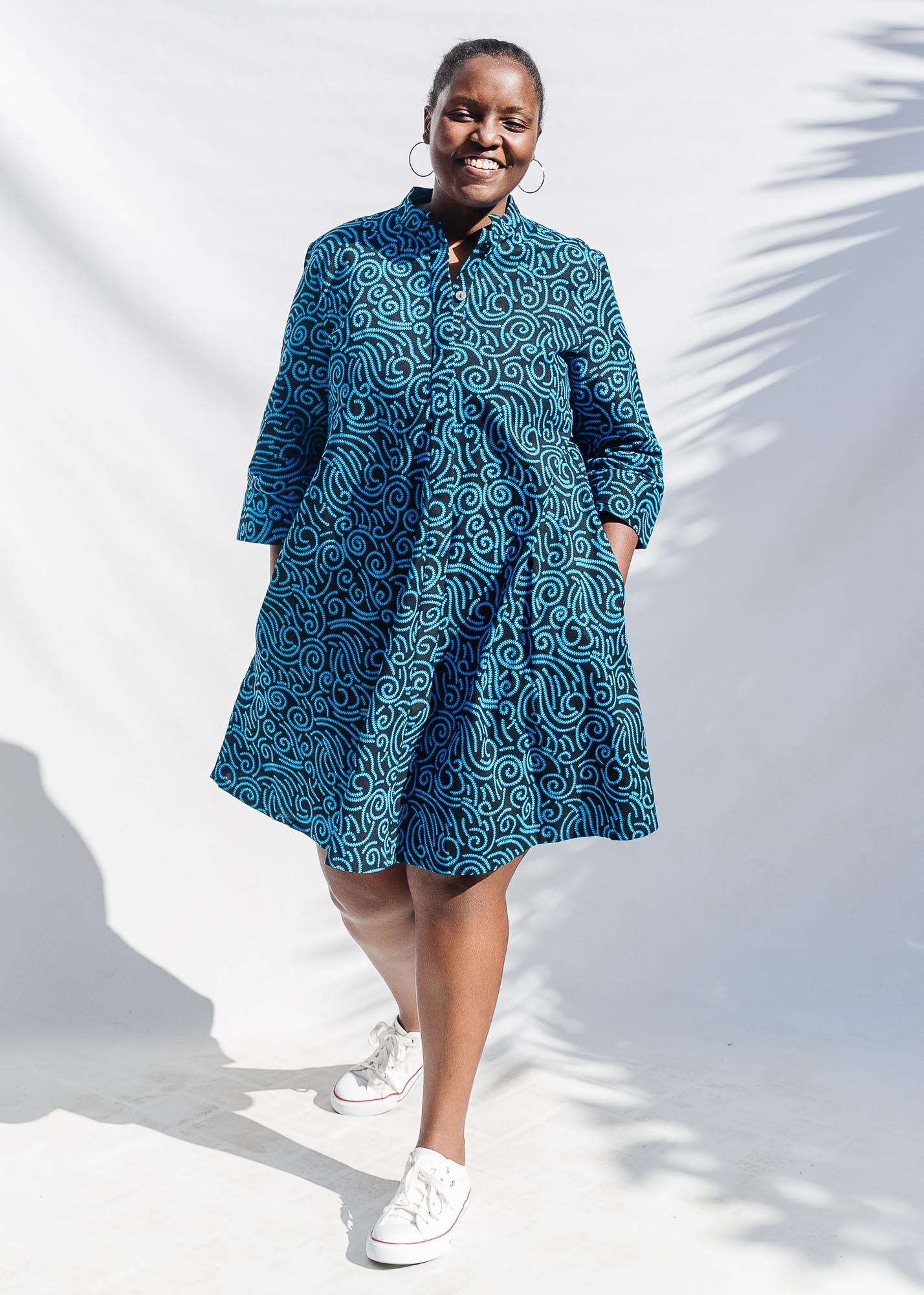 The model is wearing blue and black print dress