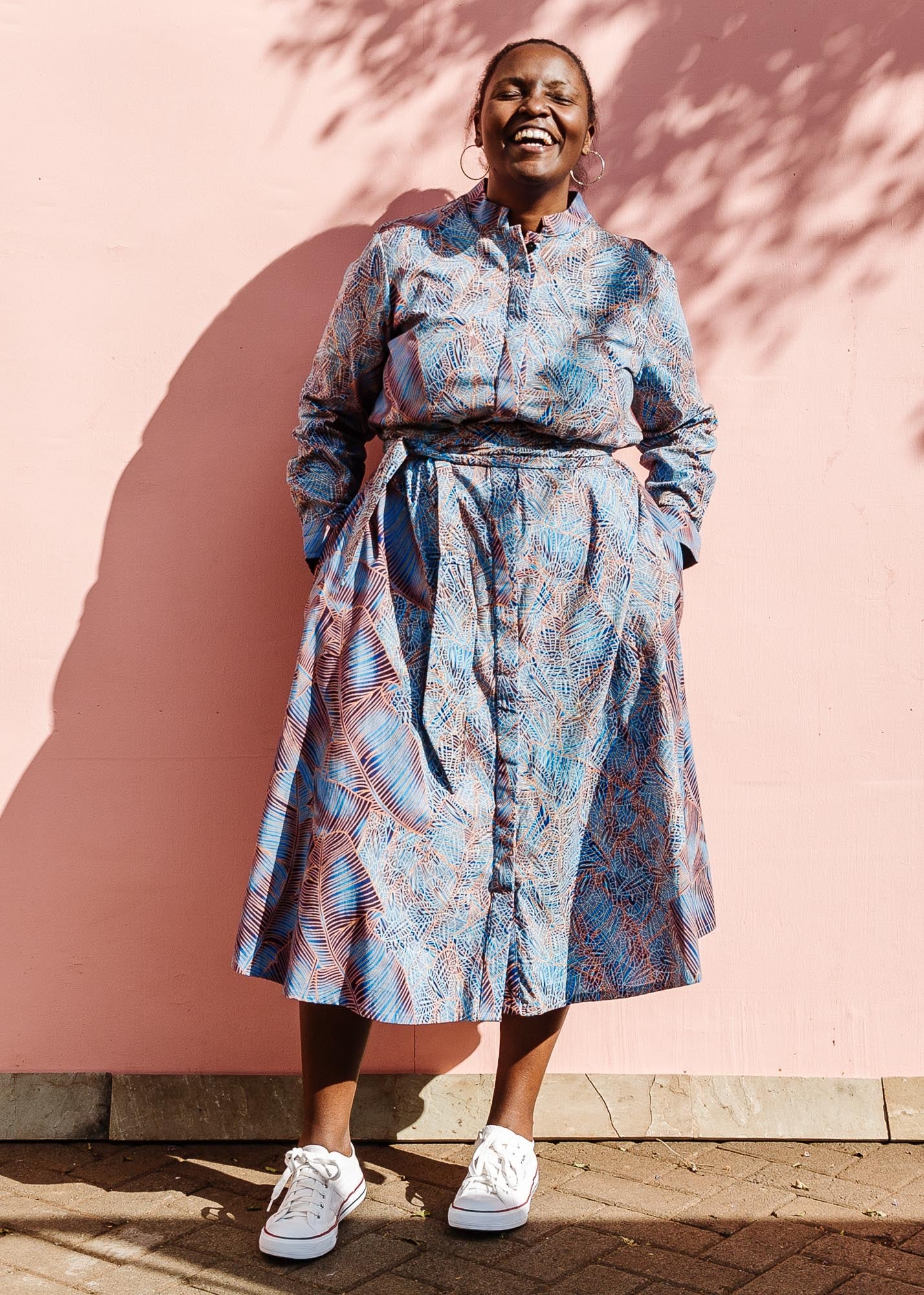 The model is wearing sky blue, blue, orange print dress