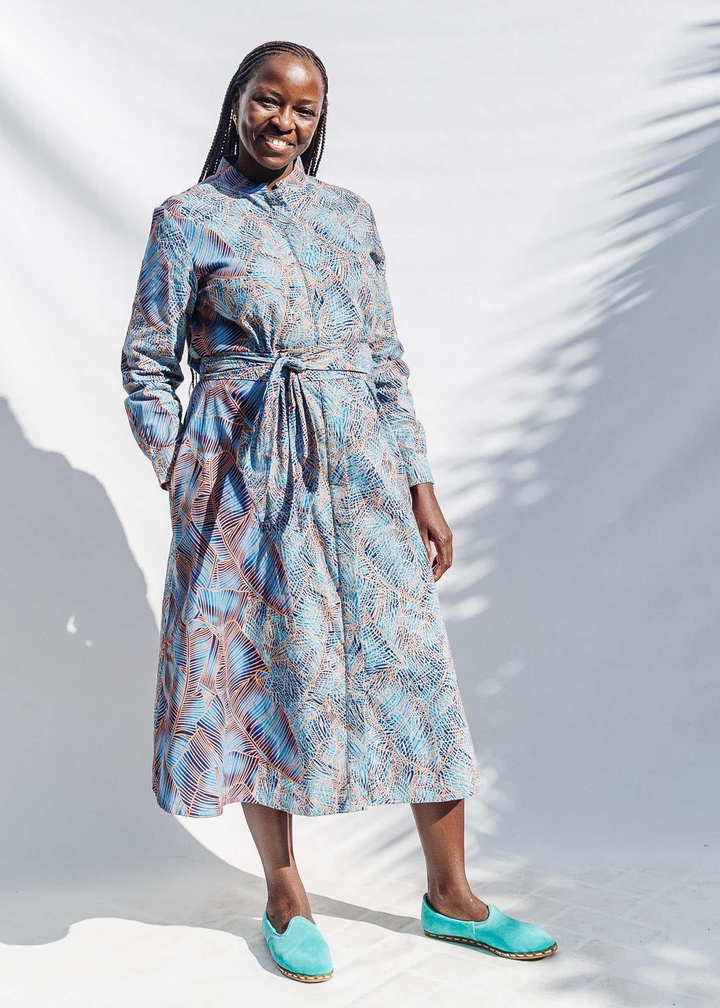 The model is wearing sky blue, blue, orange print dress 