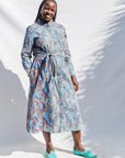 The model is wearing sky blue, blue, orange print dress 