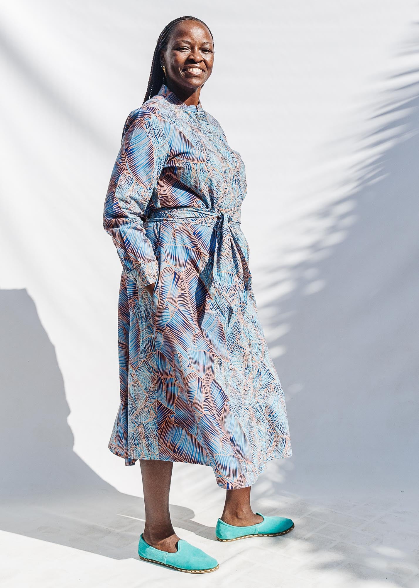 The model is wearing sky blue, blue, orange print dress