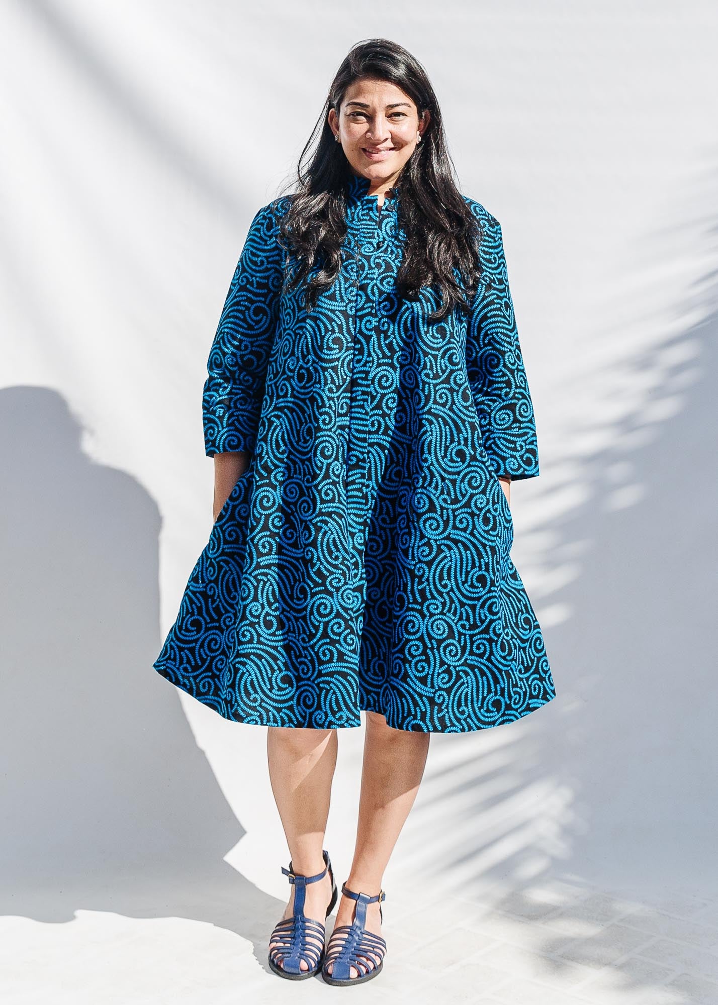 The model is wearing blue and black print dress