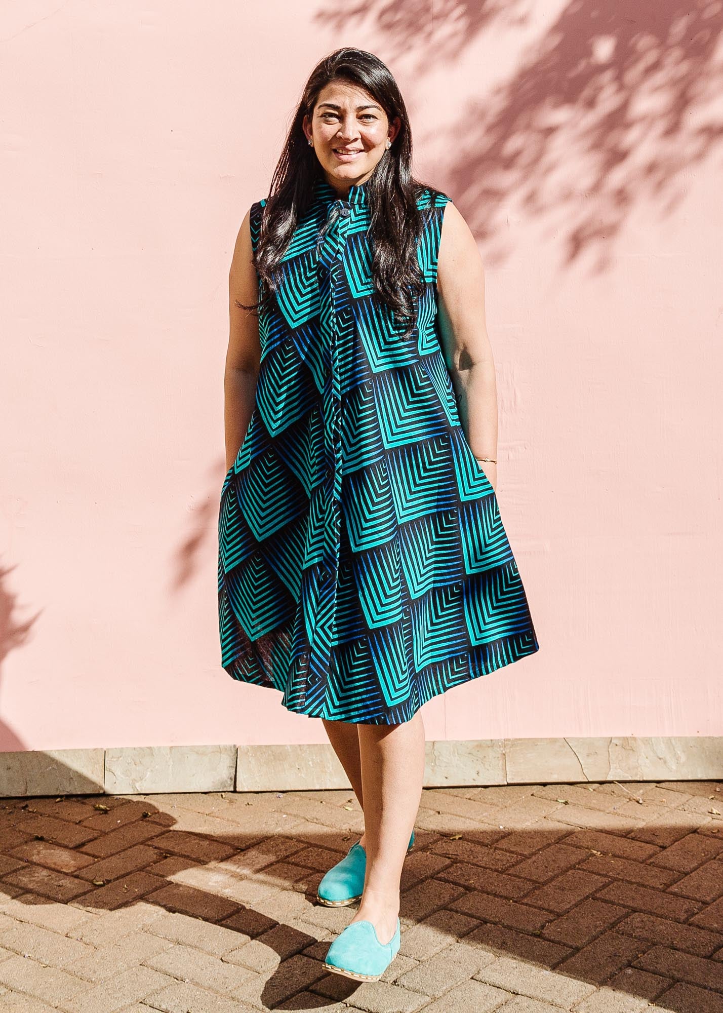 Model wearing blue and black geometric print sleeveless dress