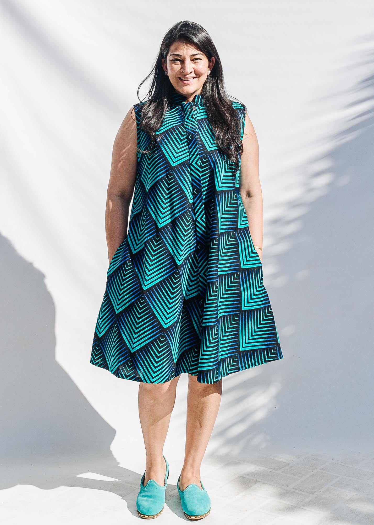 Model wearing blue and black geometric print sleeveless dress