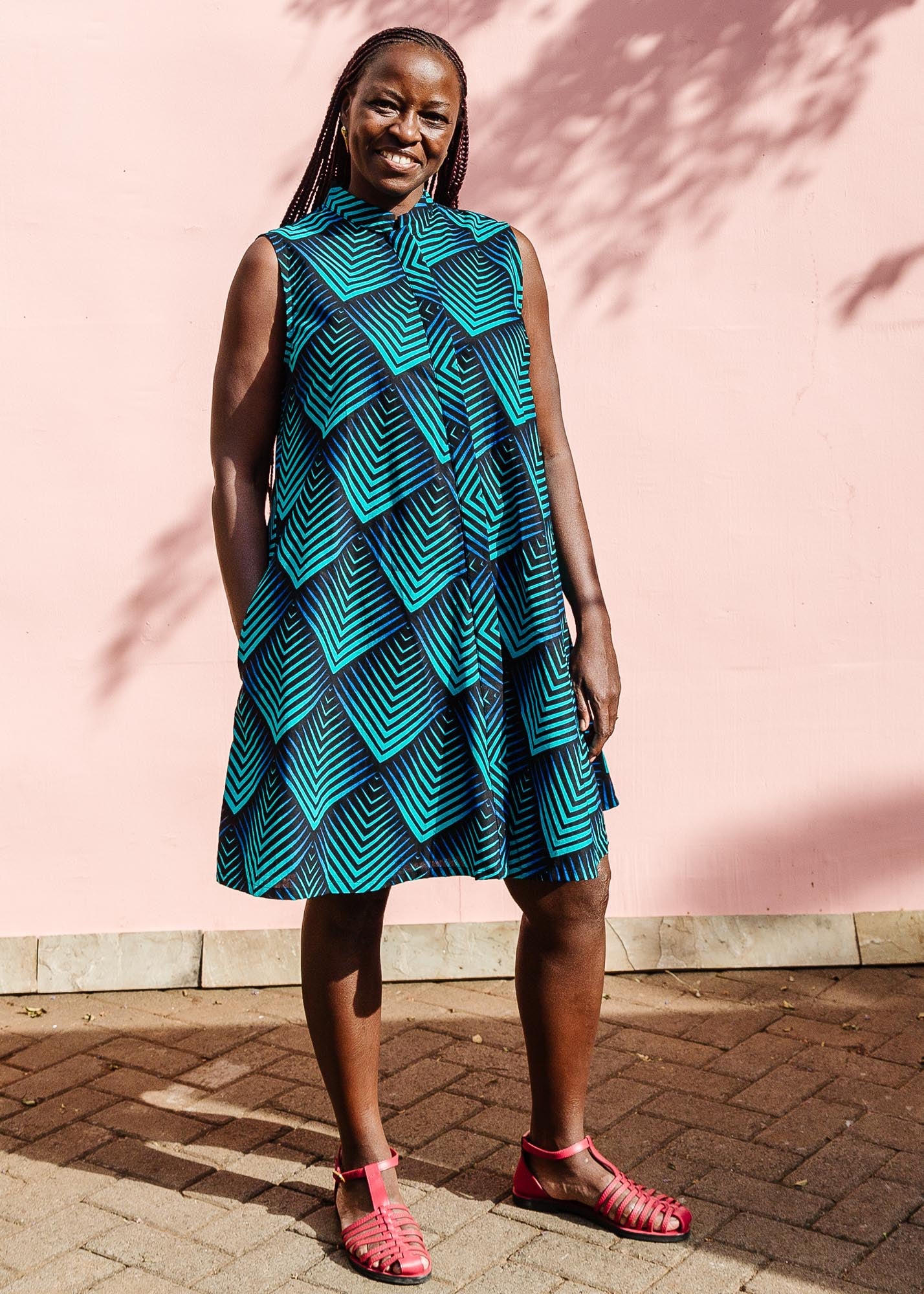 Model wearing blue and black geometric print sleeveless dress