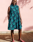 Model wearing blue and black geometric print sleeveless dress