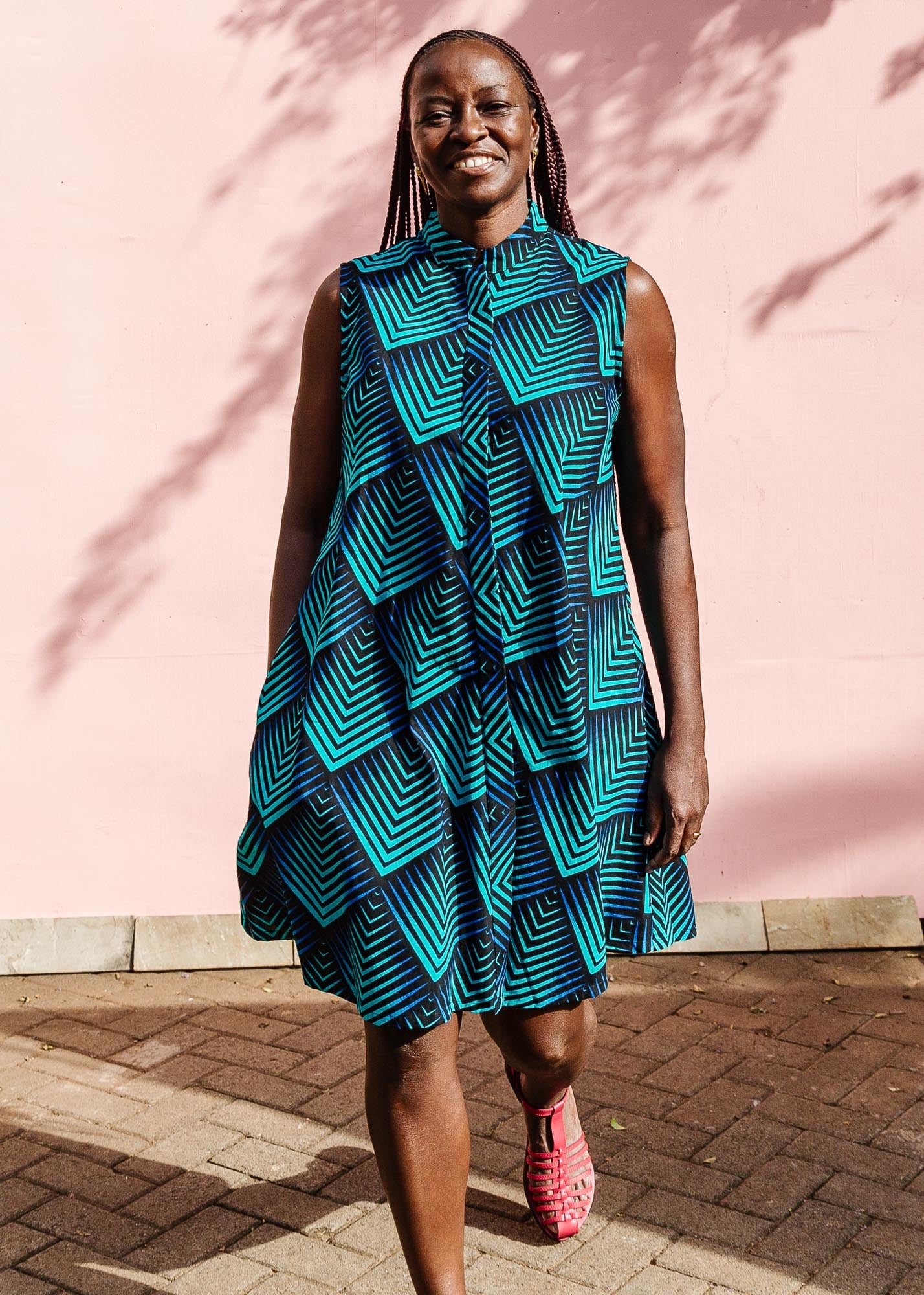 Model wearing blue and black geometric print sleeveless dress