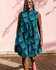 Model wearing blue and black geometric print sleeveless dress