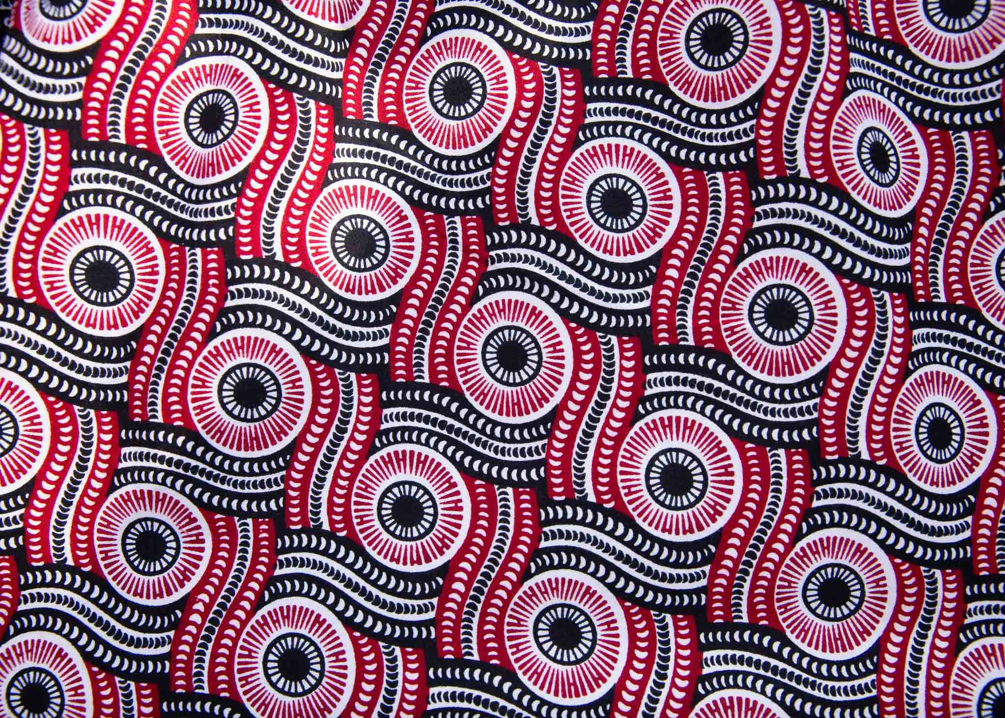 Display of long sleeve blouse with black, red, and white circles.