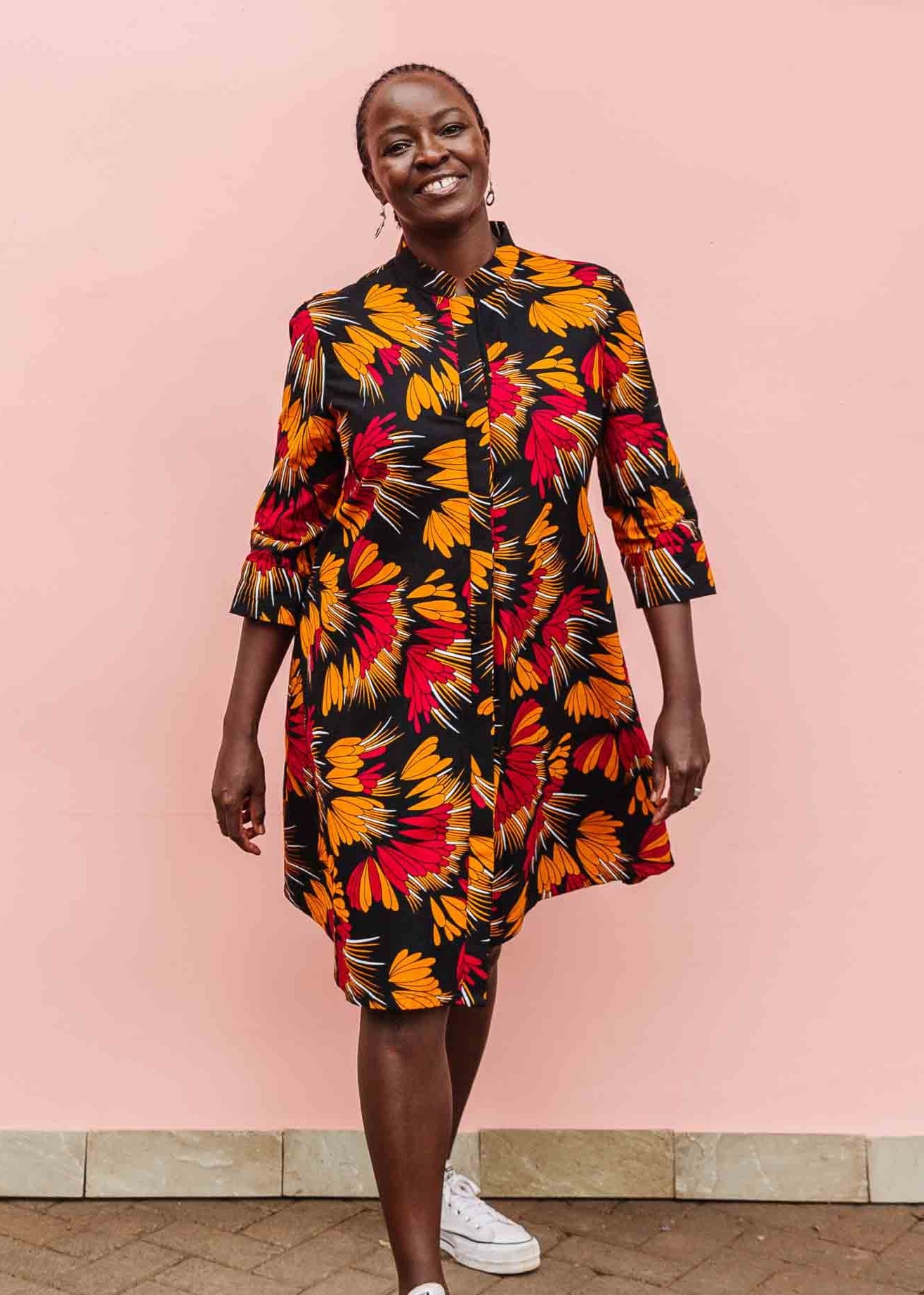 model wearing an orange, red and black floral shirt dress