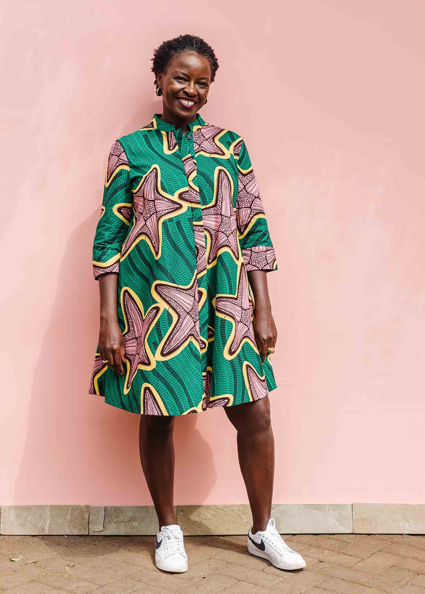Playful Ghanaian Woman in Vibrant Kente Cloth Dress - Cultural