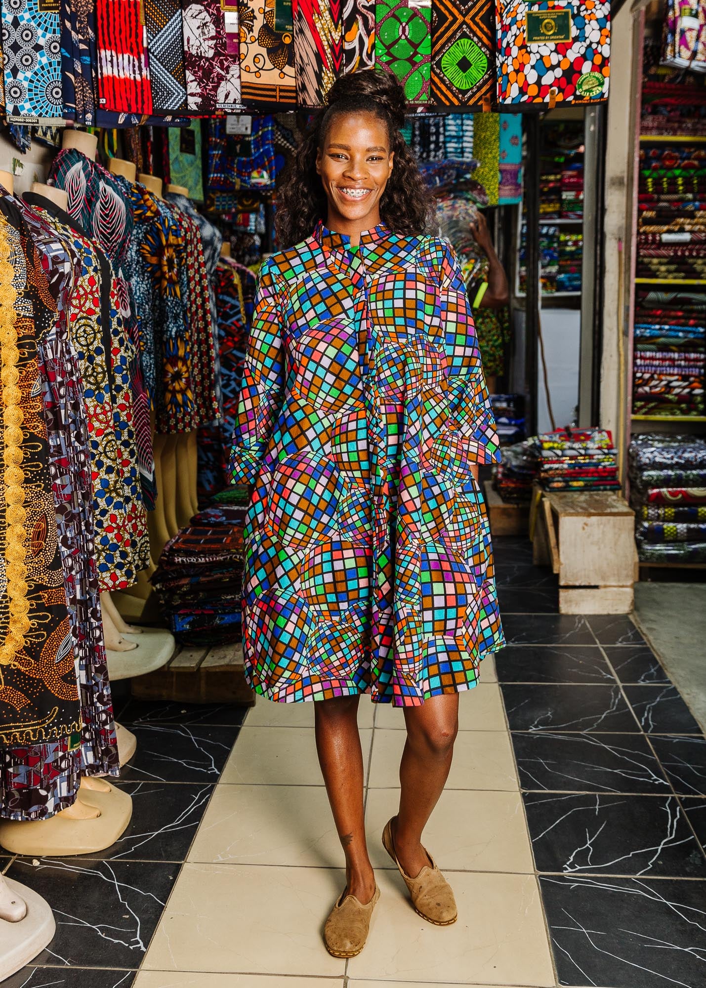 The model is wearing multi colored dress with disco ball print