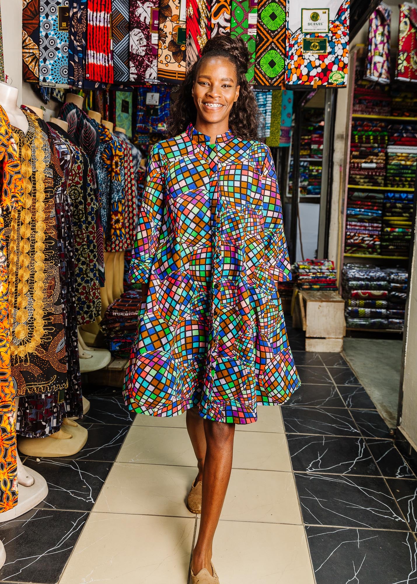 The model is wearing multi colored dress with disco ball print