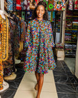 The model is wearing multi colored dress with disco ball print