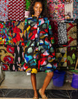 The model is wearing abstract multi-color  figures dress