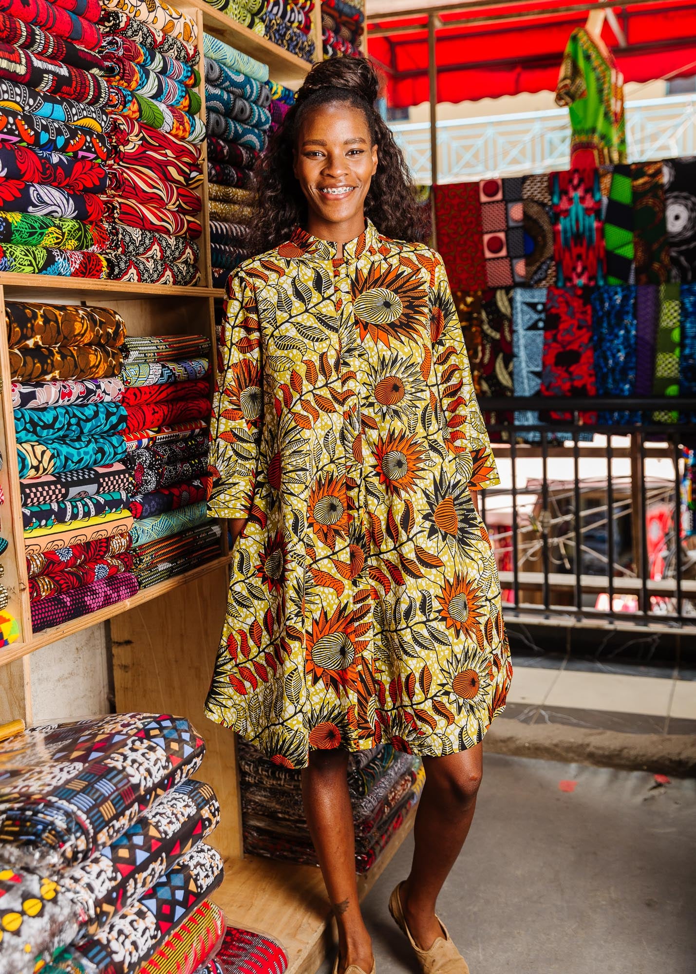 The model is wearing white and chartreuse dress with orange and black sunflowers